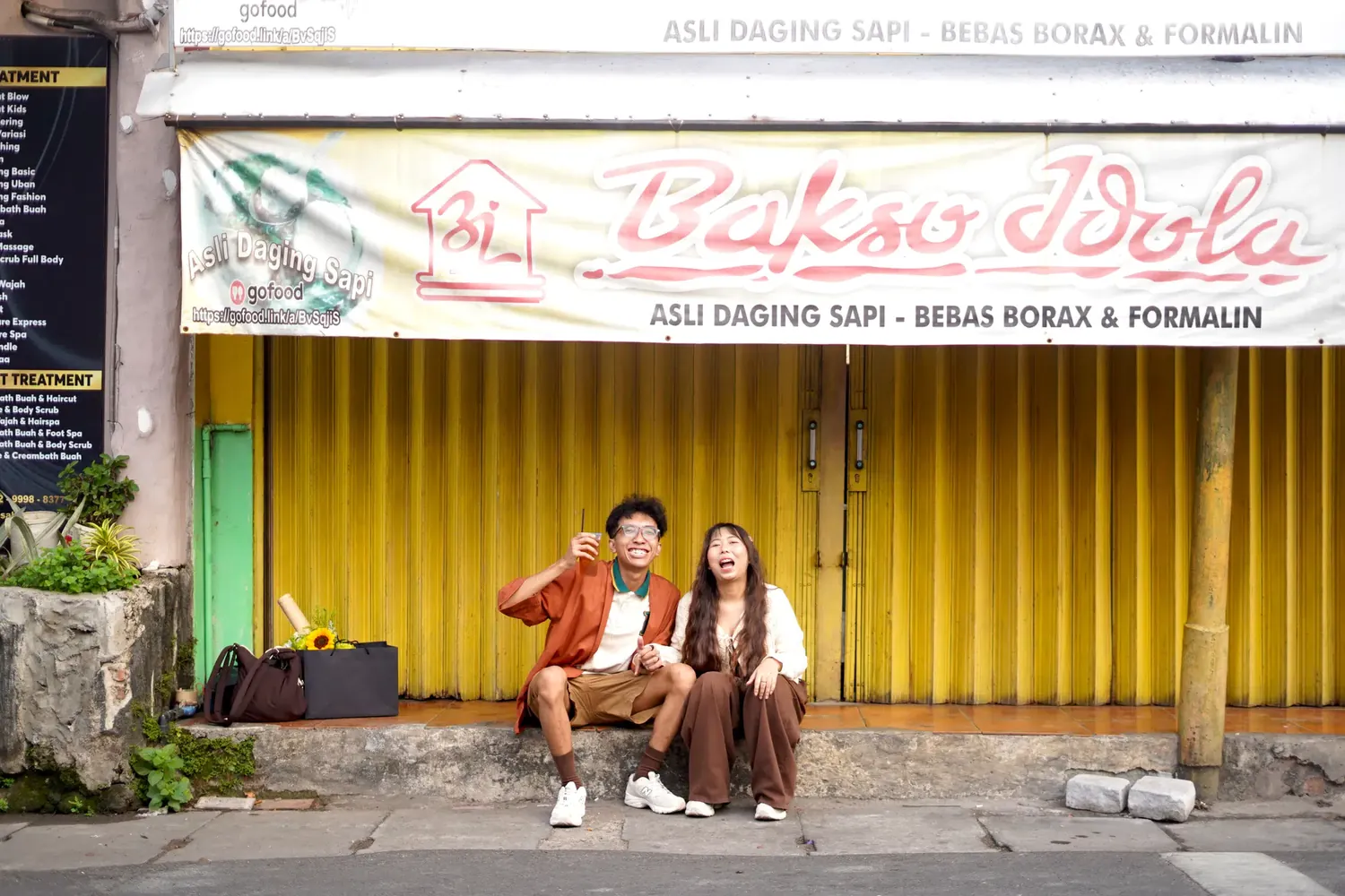 Satria dan Febianti duduk di depan kedai bakso